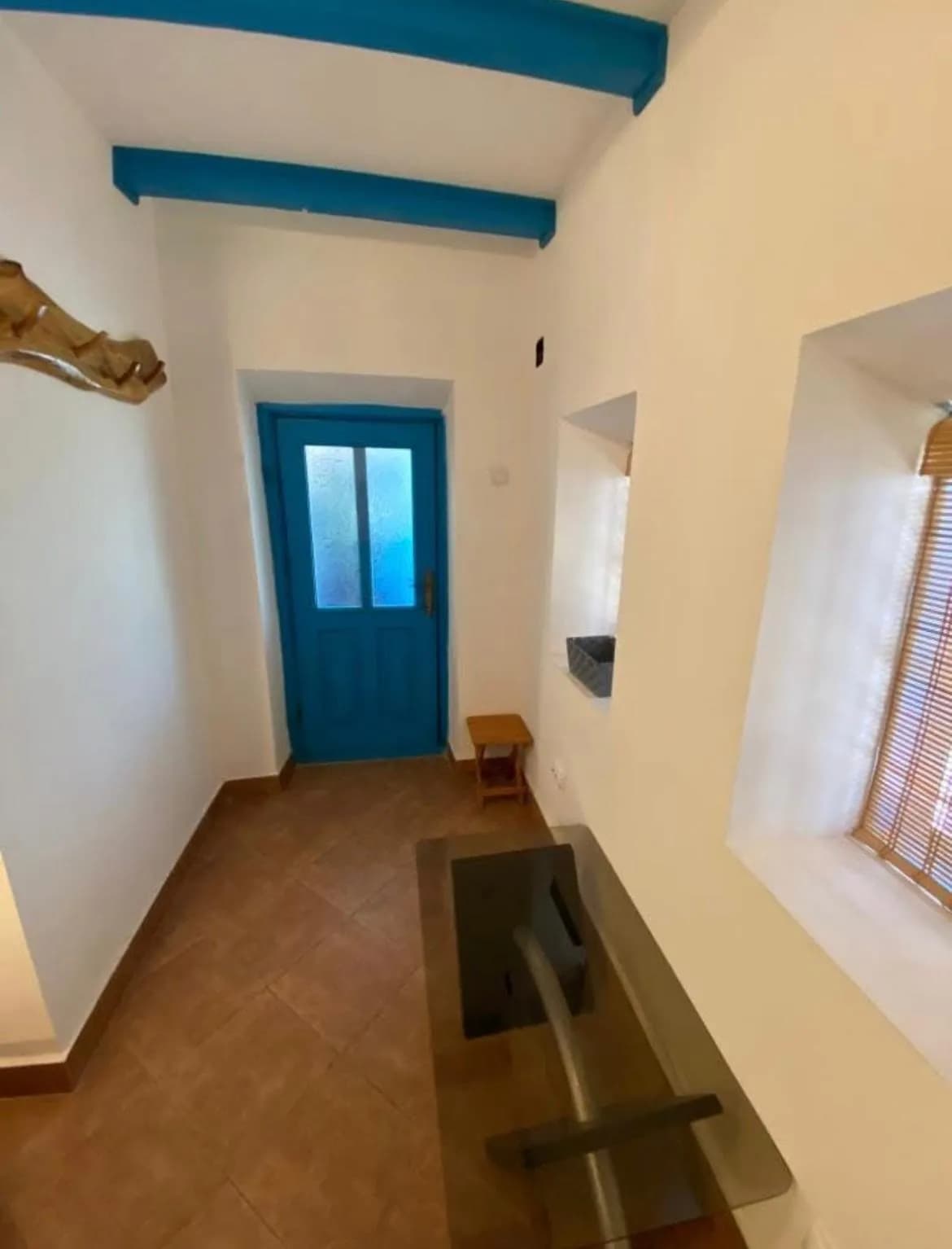 Hol cu ușă și grinzi albastre.